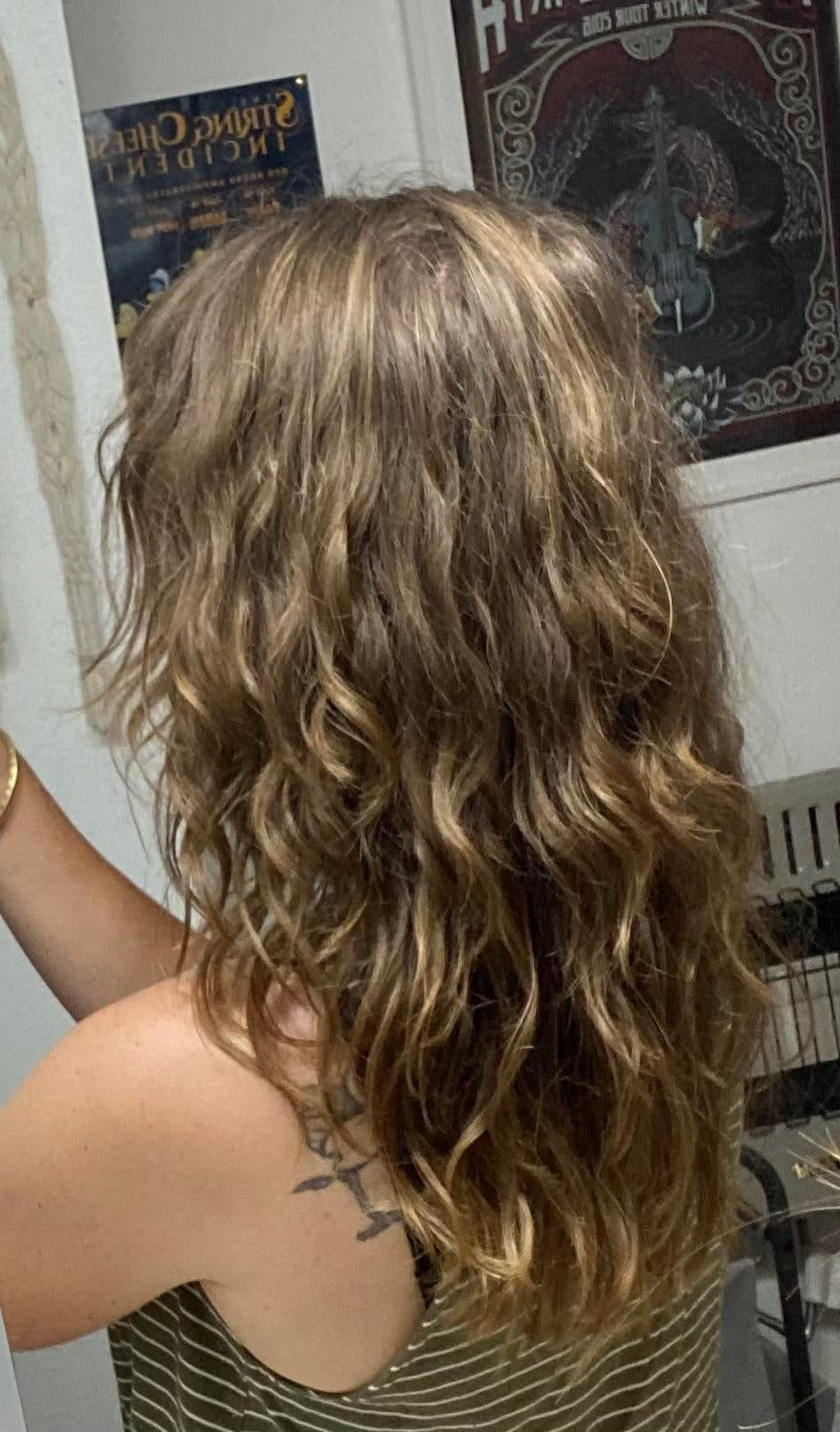 Long wavy blonde hair with loose natural curls seen from the back.