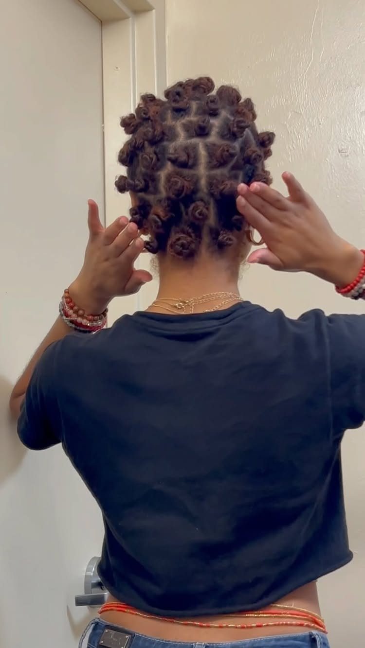 Person with dark brown hair styled in small Bantu knots from behind.