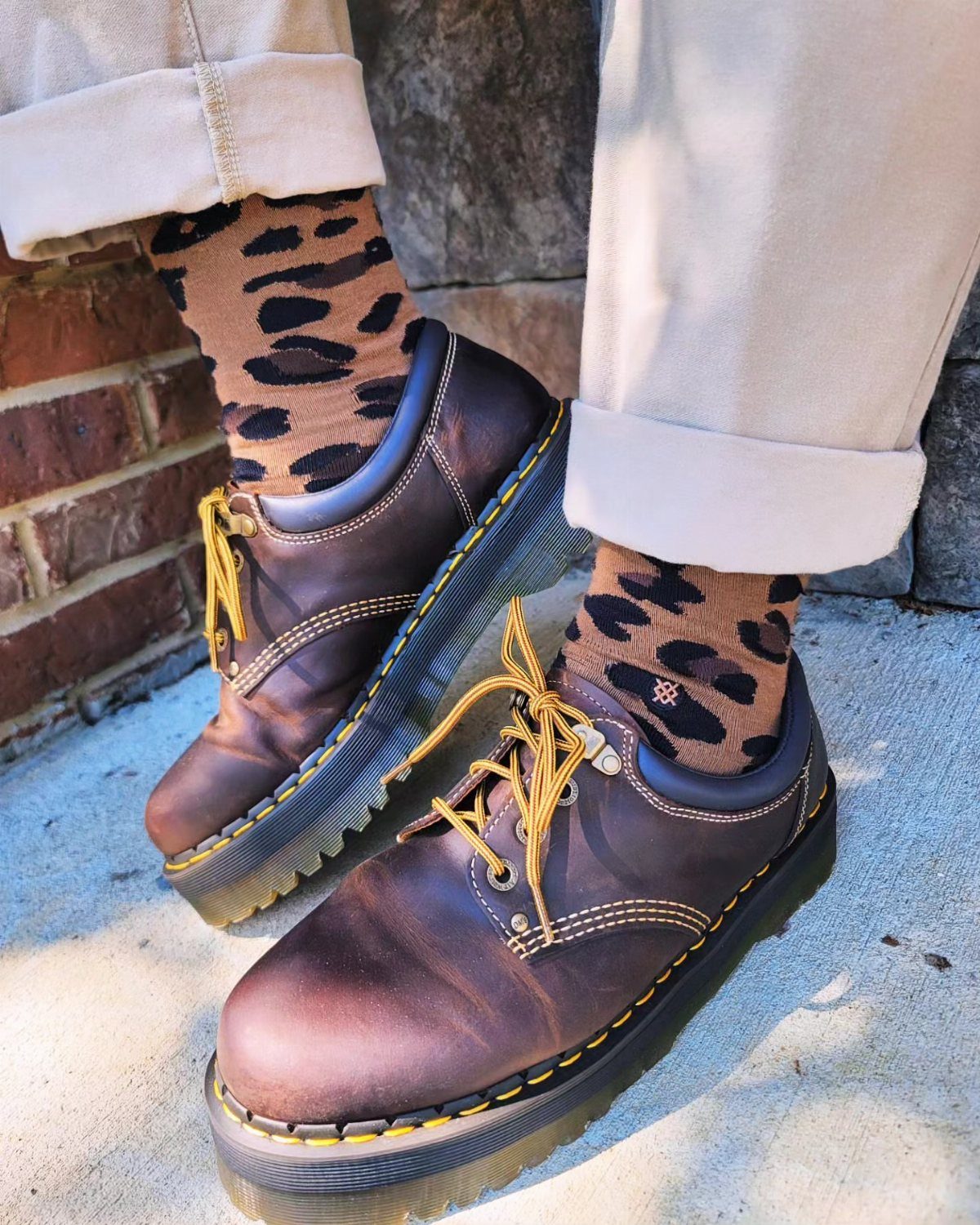 Brown leather platform casual shoes with yellow stitching and leopard print socks.