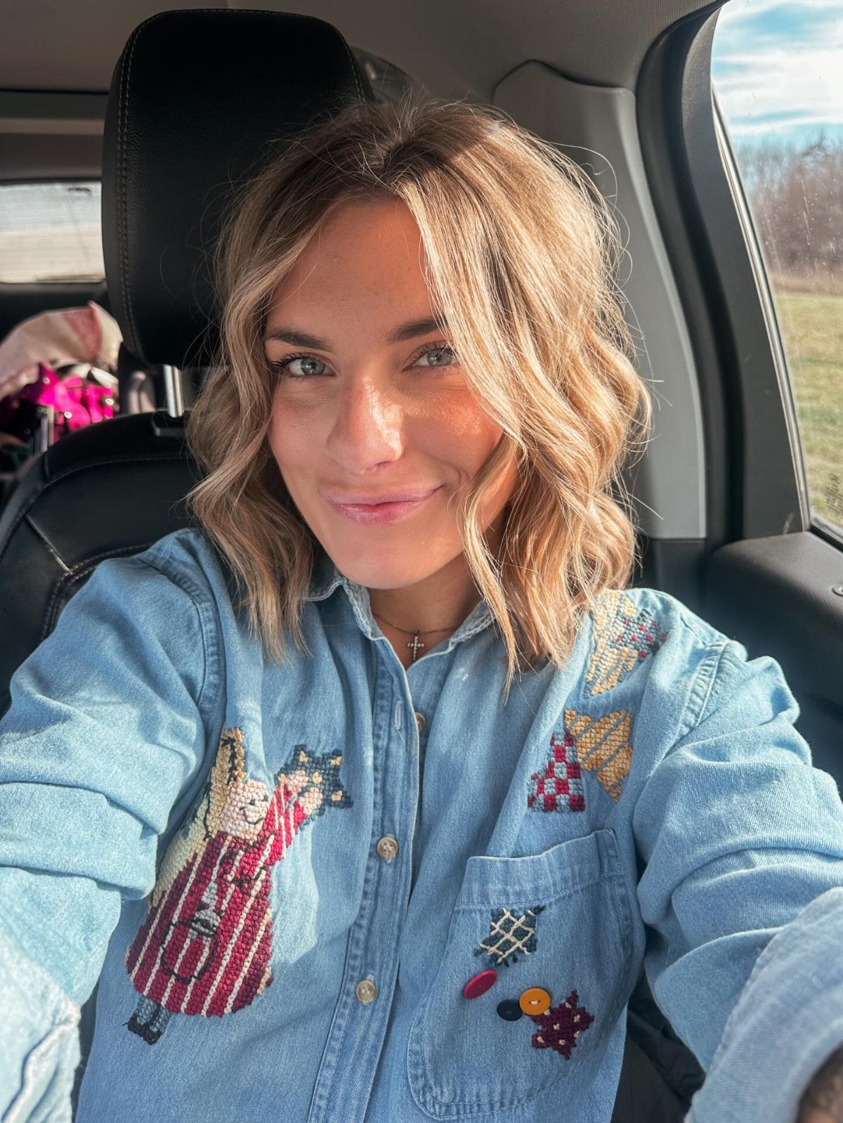 8 Outfit Ideas for 90s Country Style with Denim 7 Woman with wavy blonde hair wearing a light-wash denim shirt with colorful embroidery.