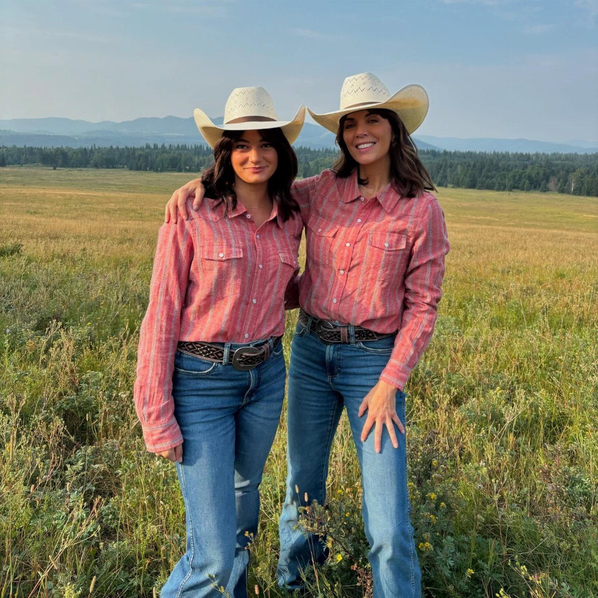 8 Outfit Ideas for 90s Country Style with Denim 5 Two women in plaid shirts, flare jeans, and cowboy hats in a field.