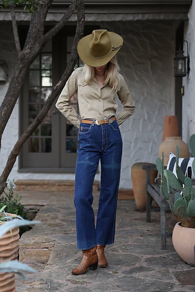 8 Outfit Ideas for 90s Country Style with Denim 3 Woman in tan button-down shirt, flare jeans, and cowboy hat on stone patio