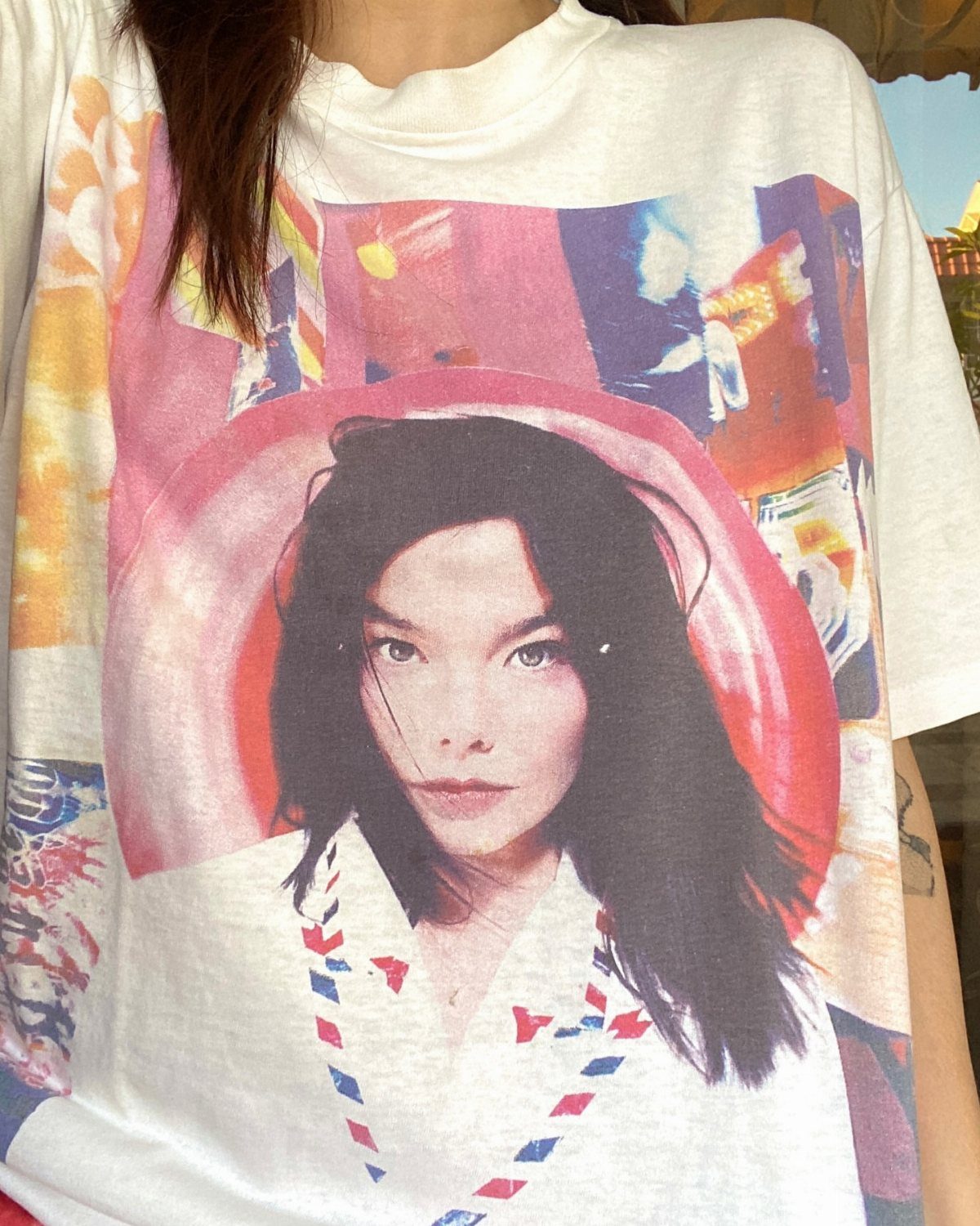 90s Vintage Streetwear Ideas: 9 Pieces Worth Wearing 1 Oversized white t-shirt with a large colorful graphic print of a woman's face.