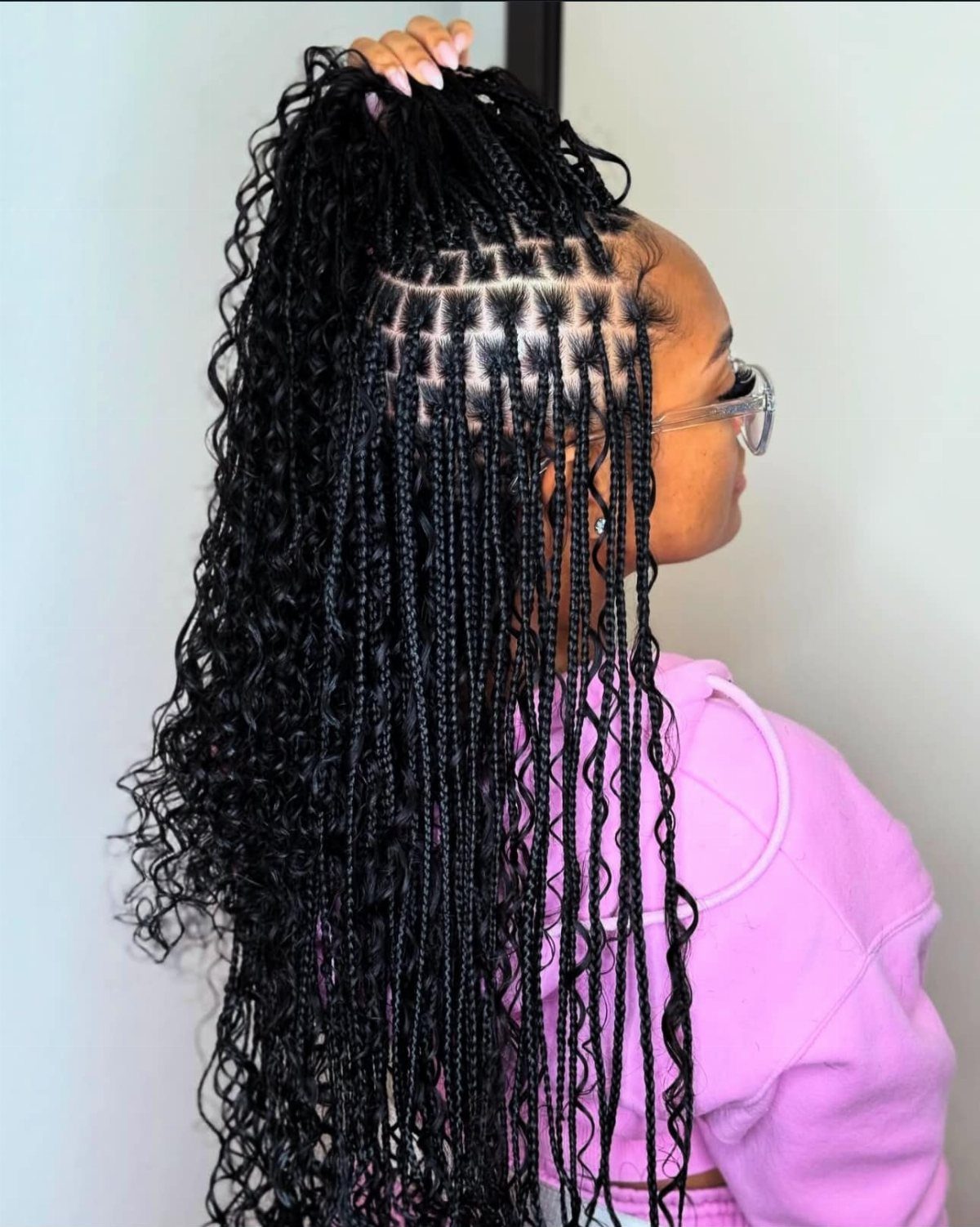 20 African Hair Styles Braids 6 Woman with long black braids and curly ends styled in a high ponytail.
