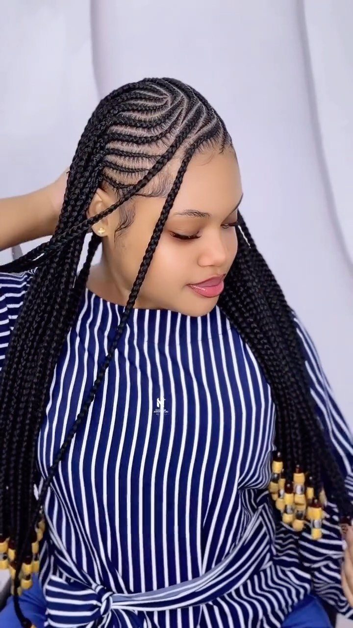 20 African Hair Styles Braids 11 Woman with black Ghana braids and wooden beads wearing a striped blue top.