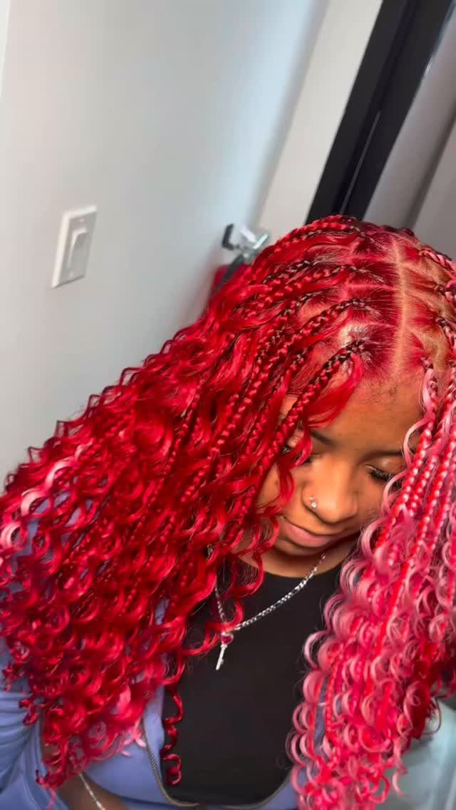 20 African Hair Styles Braids 5 Person with thick red and pink jumbo braids with curly ends and silver jewelry.