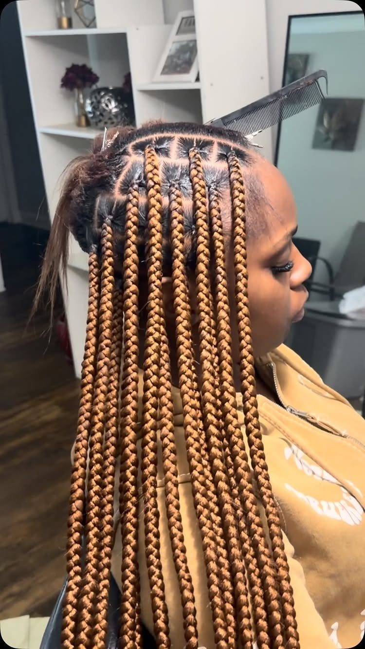 20 African Hair Styles Braids 1 Woman with long honey-blonde knotless braids styled in a neat grid pattern.