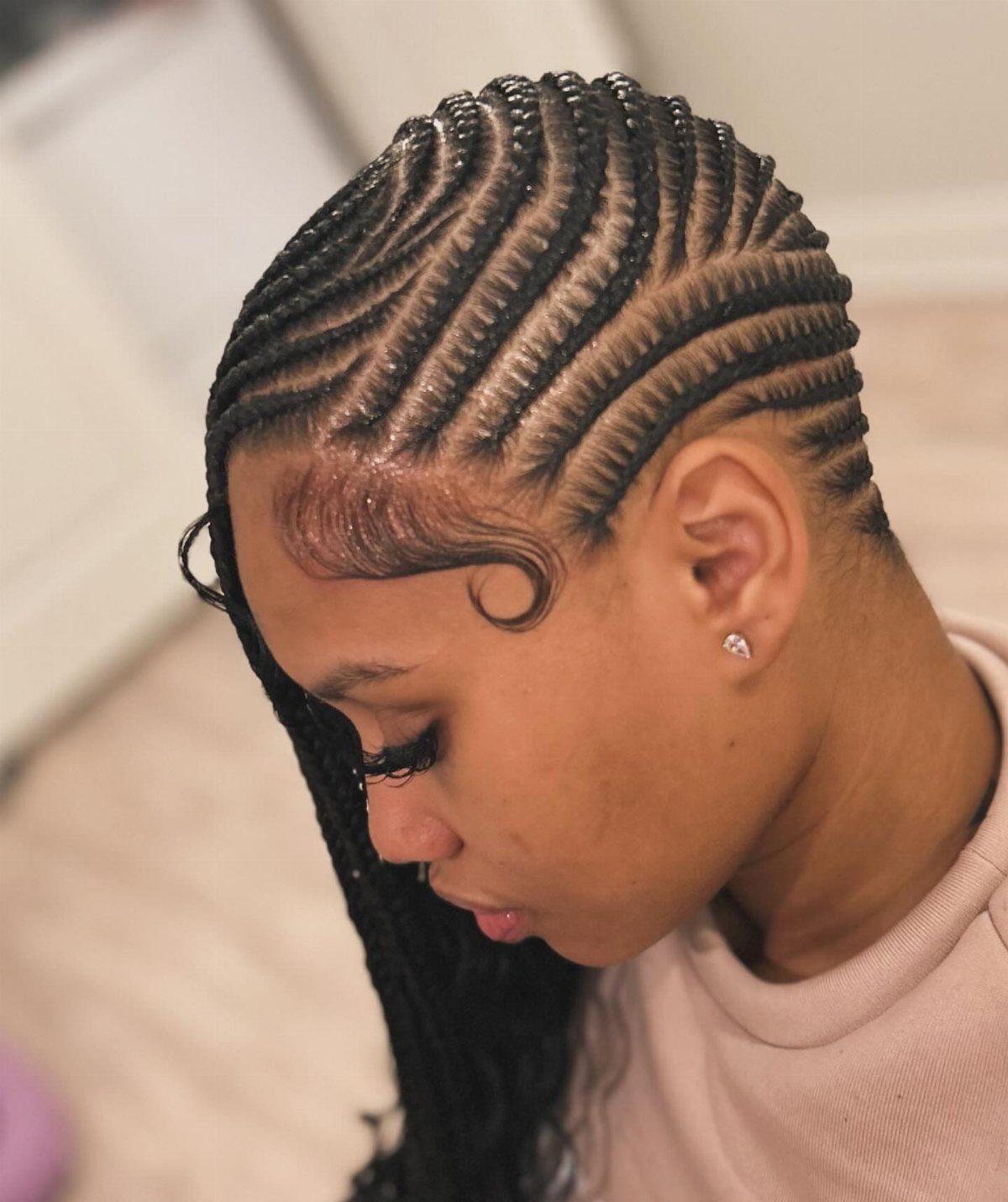 20 African Hair Styles Braids 13 Woman with side-swept cornrows in a lemonade braids style, profile view.