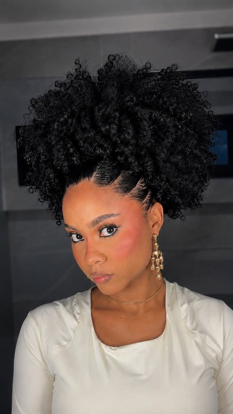 Afro Hair 4c Style Ideas: 19 Looks From Cornrows to Locs 10 Woman with black 4C hair styled in a voluminous high puff and gold jewelry.