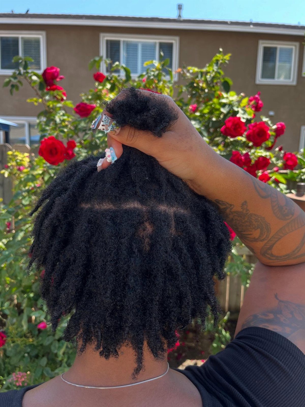 Afro Hair 4c Style Ideas: 19 Looks From Cornrows to Locs 8 Person with short black locs posing in front of red rose bushes.
