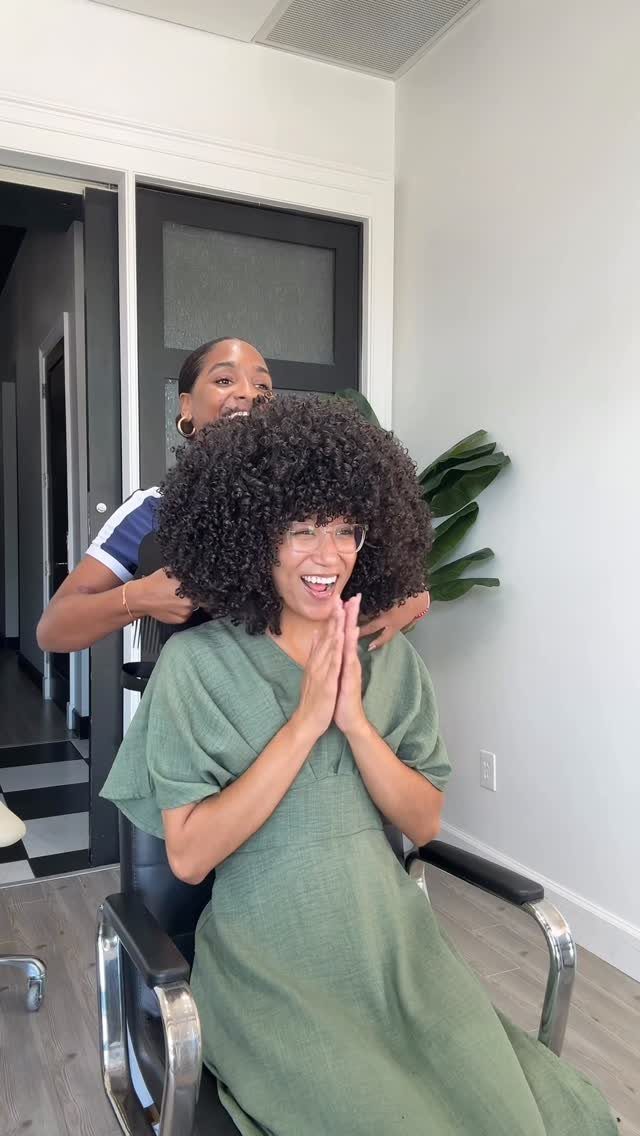 Afro Hair 4c Style Ideas: 19 Looks From Cornrows to Locs 4 Woman with a voluminous rounded afro smiling in a bright hair salon.