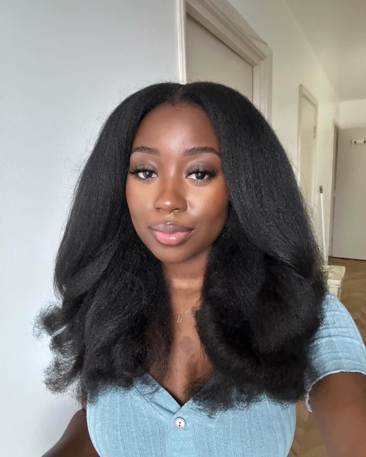 Afro Hair 4c Style Ideas: 19 Looks From Cornrows to Locs 16 Woman with voluminous, stretched out 4C natural hair and a light blue shirt.