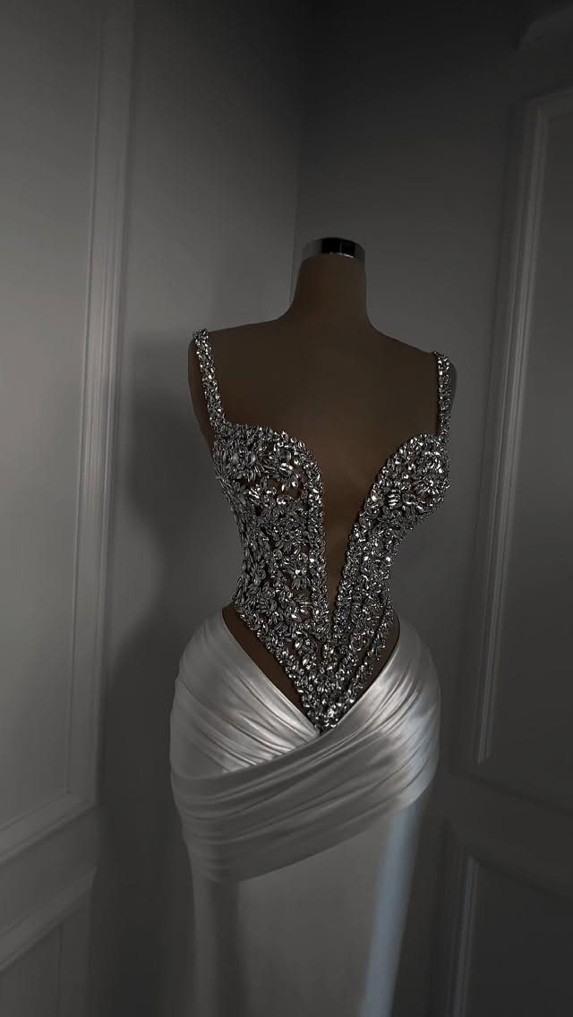White wedding dress on mannequin with deep V-back and silver floral beadwork.