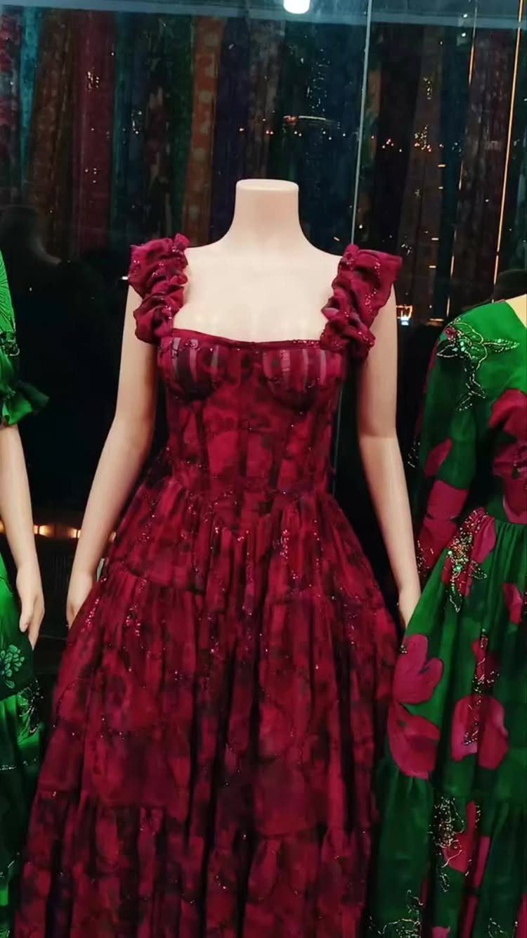 Maroon gown with ruffled straps and full skirt on a mannequin