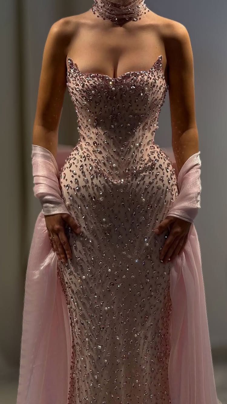 Woman in a shimmering strapless pink gown with matching opera gloves and choker.