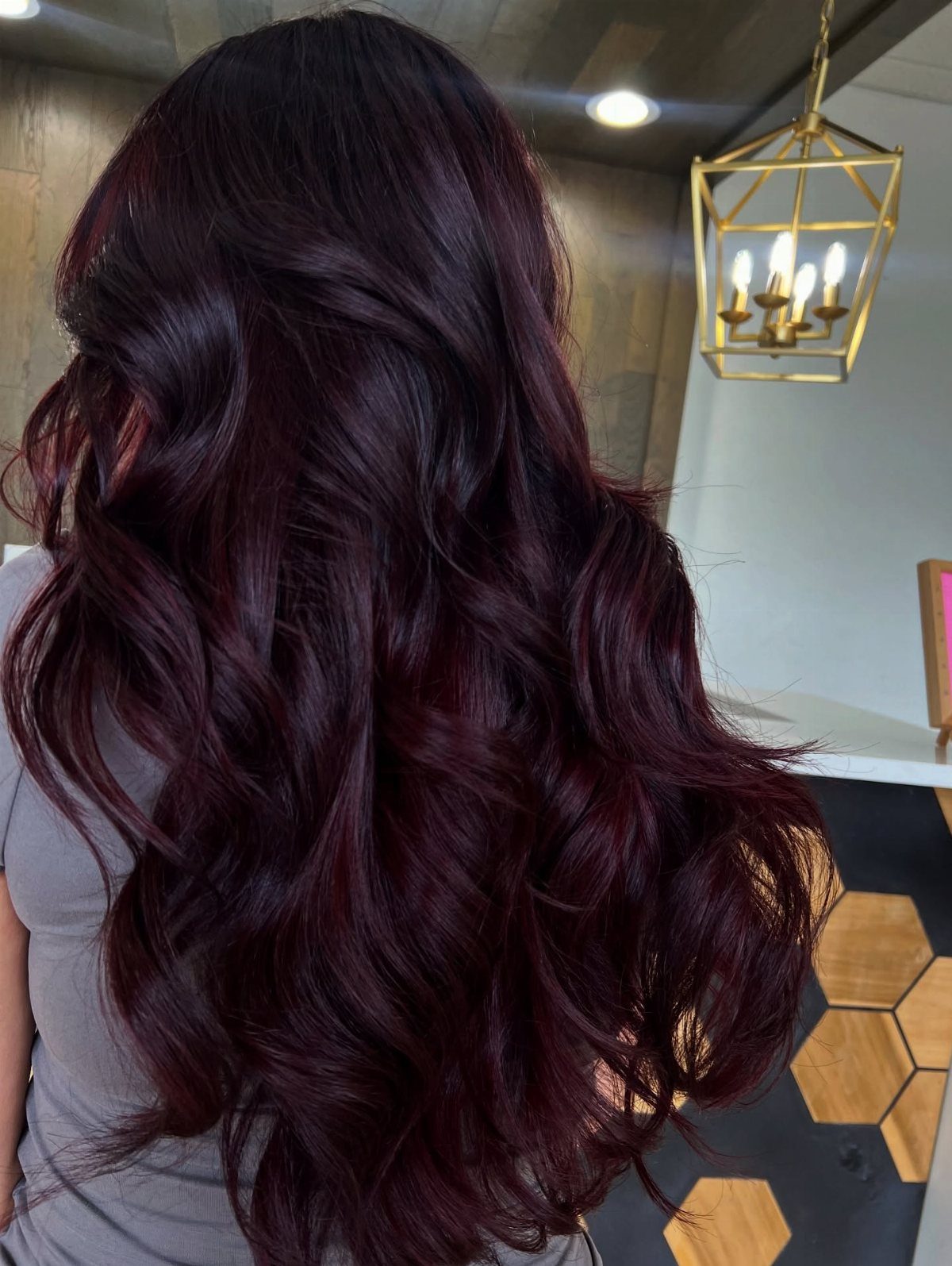 5 Black Cherry Hair Ideas for Deep, Glossy Color 4 Long wavy black cherry red hair with a glossy, reflective shine from behind.