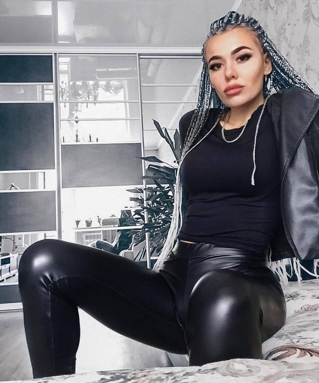5 Blackout Party Outfits for a Night of Head-to-Toe Black 5 Woman with blue braids wearing black leather leggings and a black jacket.