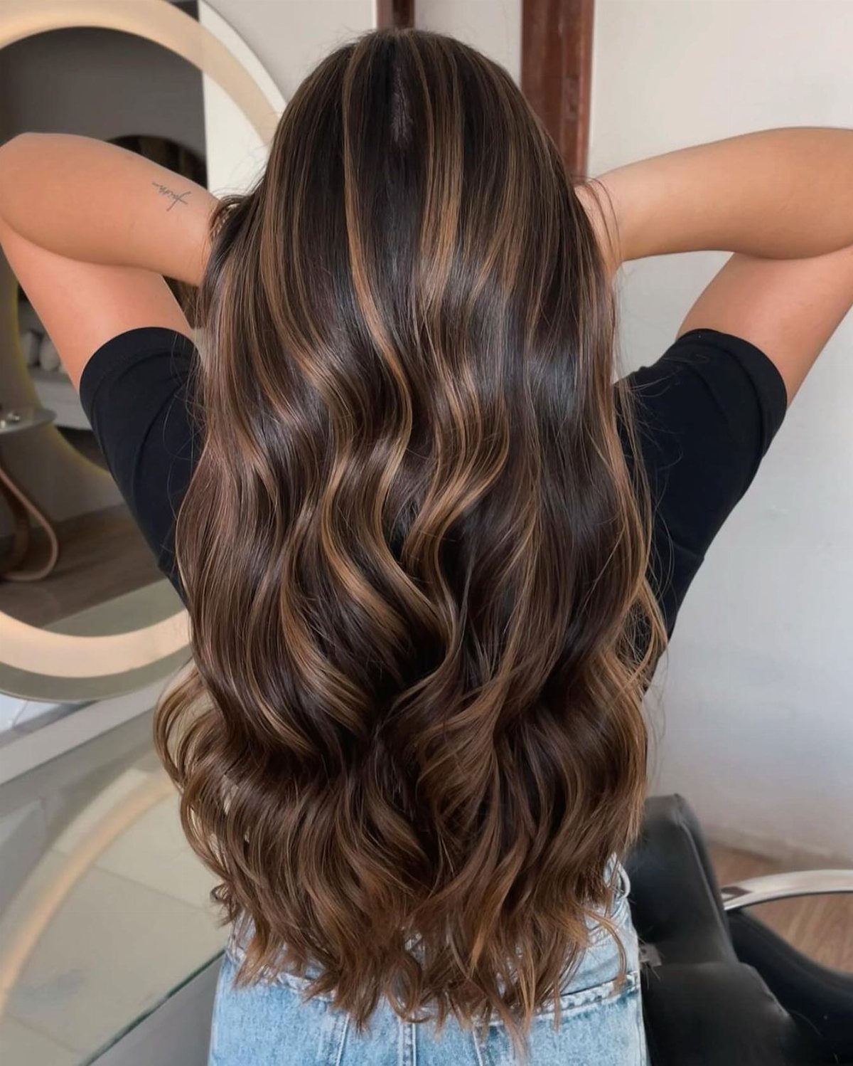 Long wavy brown hair with golden blonde highlights seen from the back.