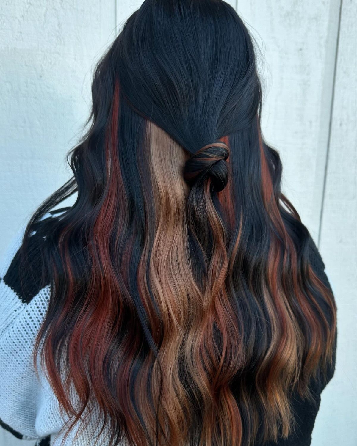 Long wavy dark brown hair with chunky copper and warm brown highlights.