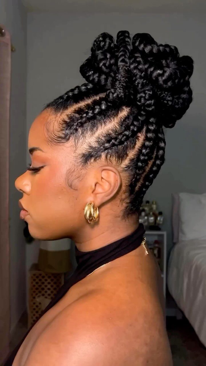 Woman with black cornrow braids styled into a high braided bun.