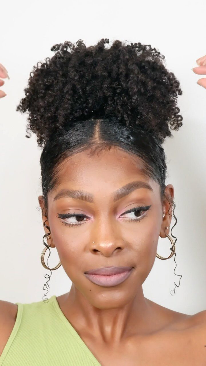 Woman with curly black hair styled in a high pineapple updo ponytail.