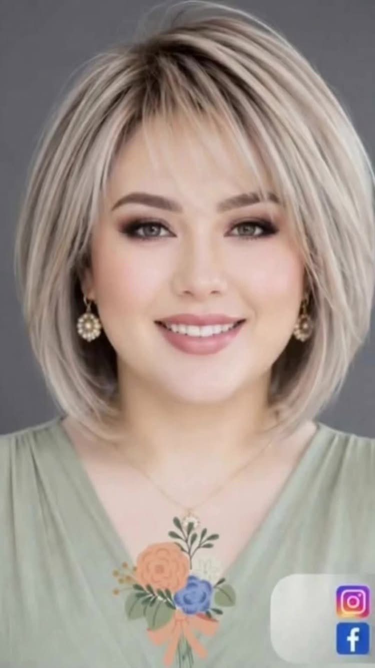Woman with a blonde layered bob haircut and bangs smiling at the camera.