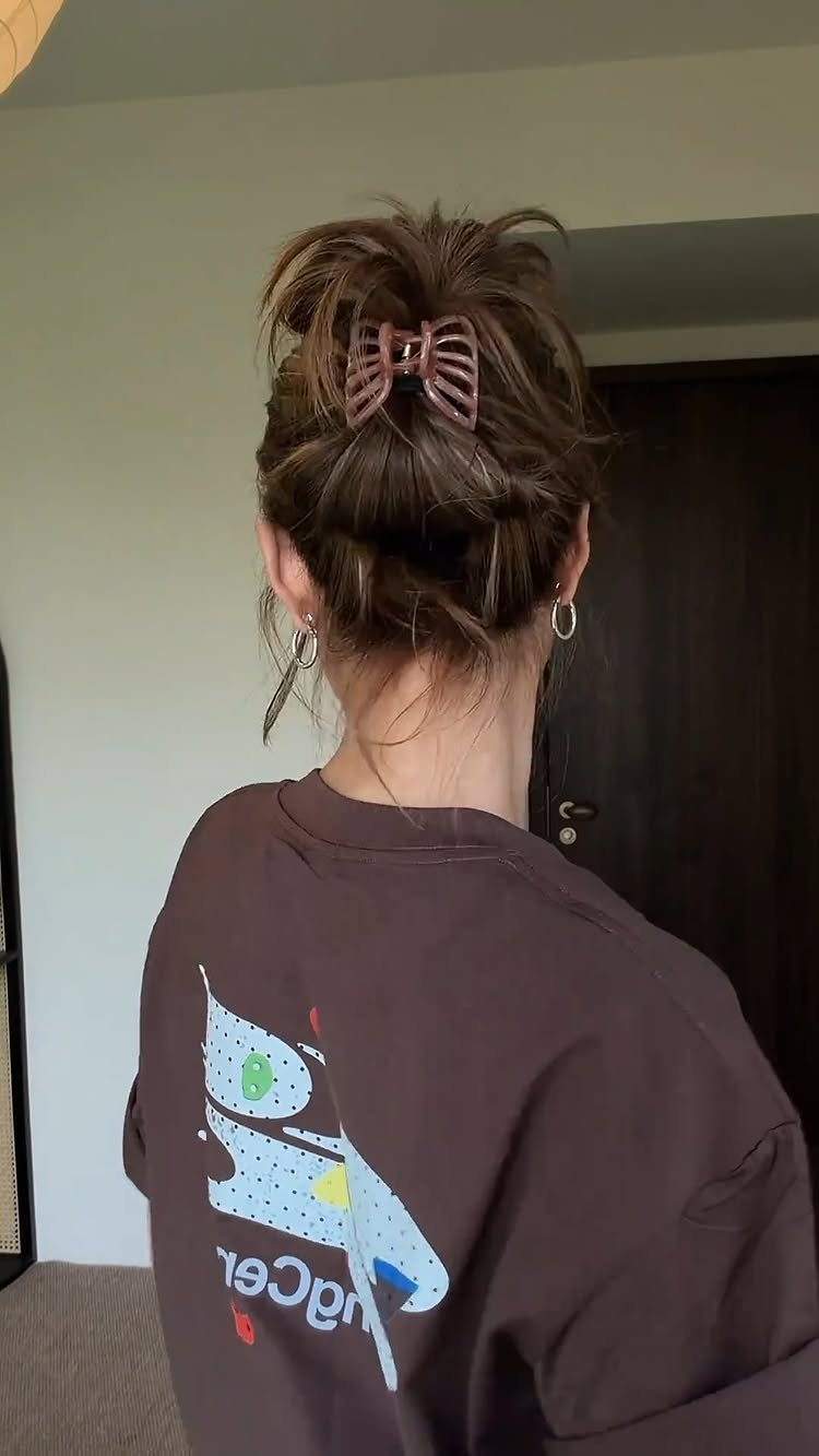 Brown hair styled in a messy bun secured with a brown claw clip.