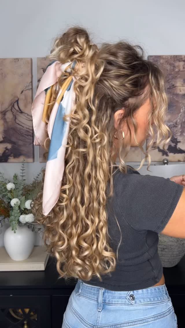 Woman with curly blonde hair in a half-up ponytail wrapped in a silk scarf