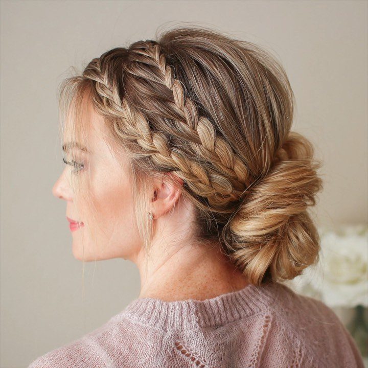 Woman with blonde hair in a Dutch braid and low textured bun.