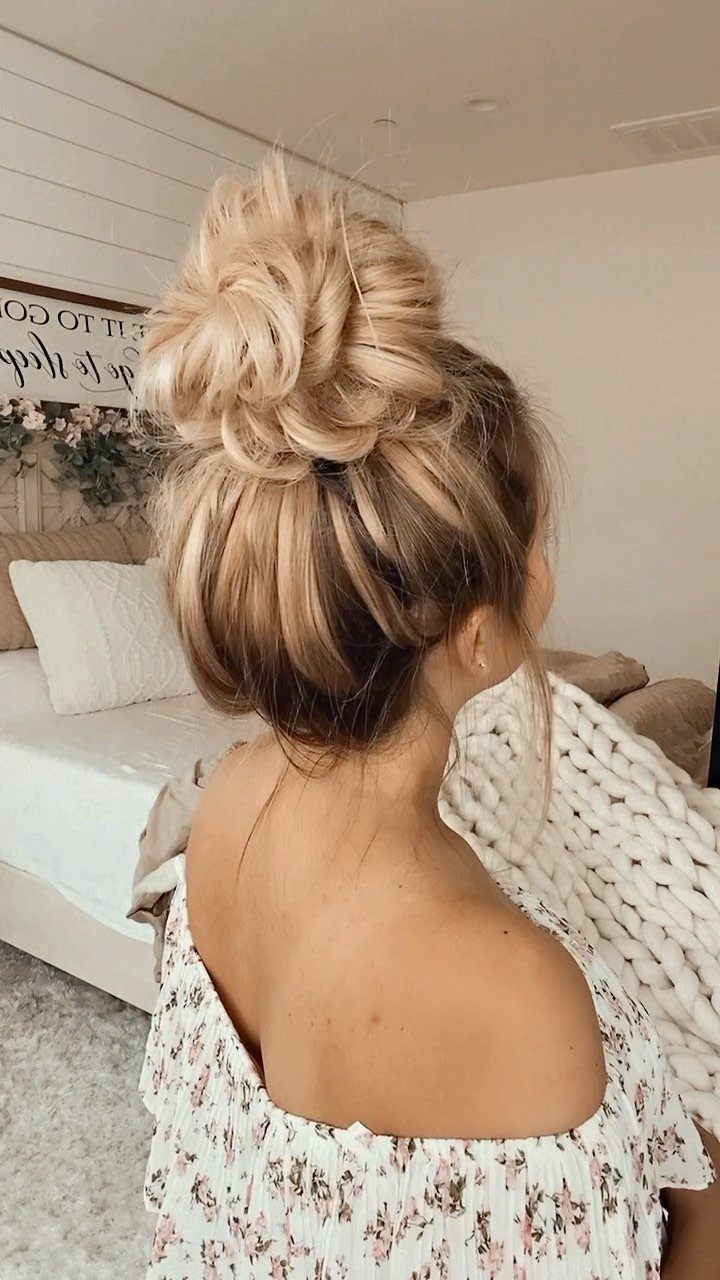 Woman with blonde hair styled in a large, voluminous topknot bun from behind.