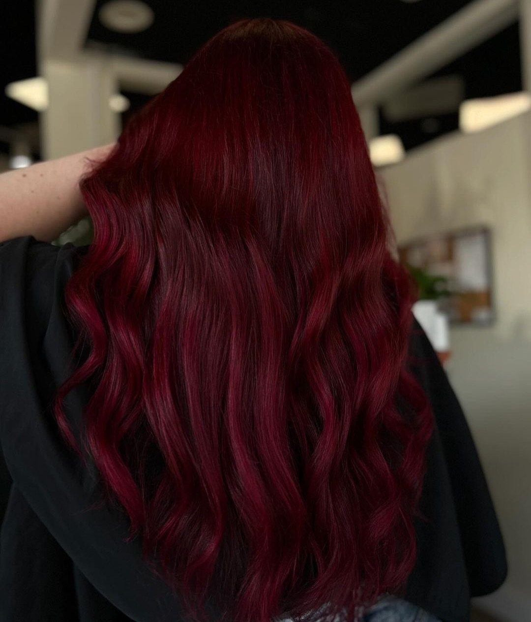 8 Deep Red Hair Dye Ideas for Every Cut and Texture 1 Long wavy deep red burgundy hair seen from the back of a person.