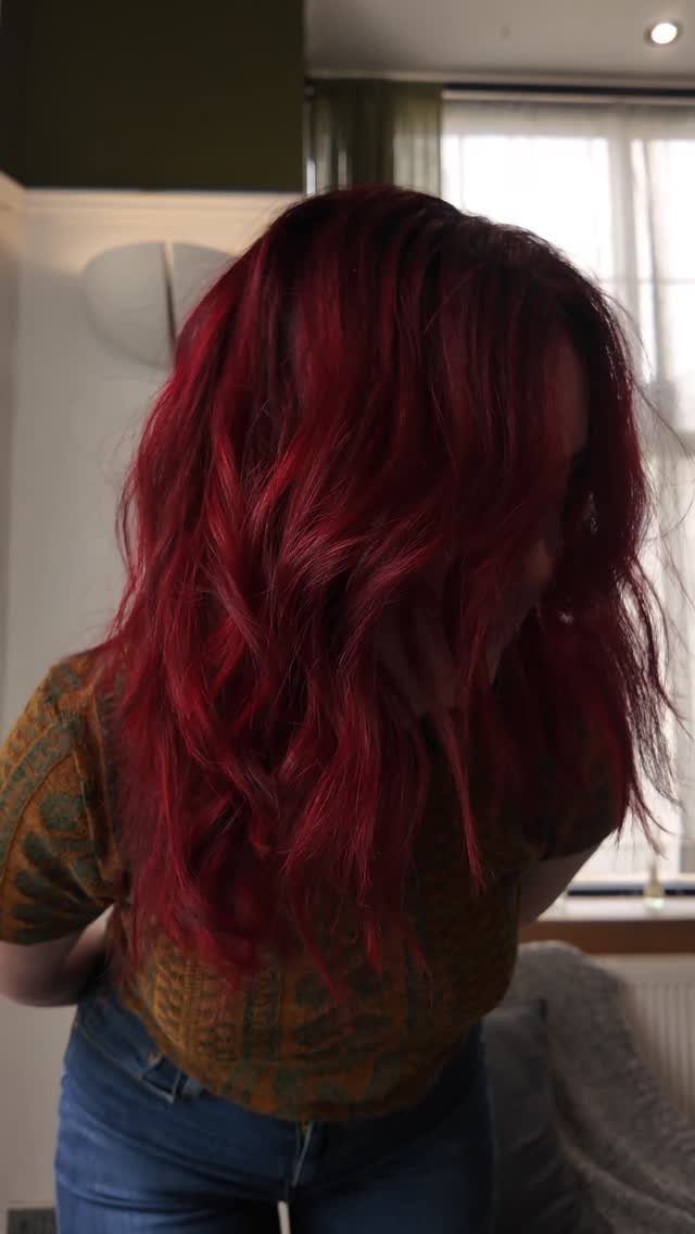 8 Deep Red Hair Dye Ideas for Every Cut and Texture 2 Person with long wavy deep red hair wearing a brown patterned shirt