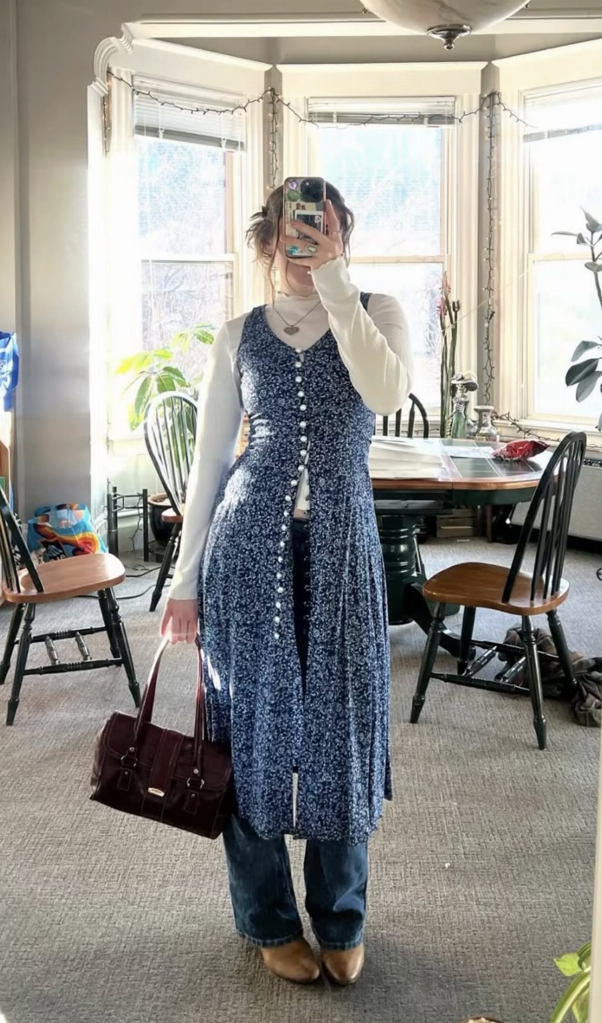 5 Ways to Wear a Dress with Long Sleeves Underneath 5 Person wearing a white long-sleeve top under a blue floral summer dress and jeans.