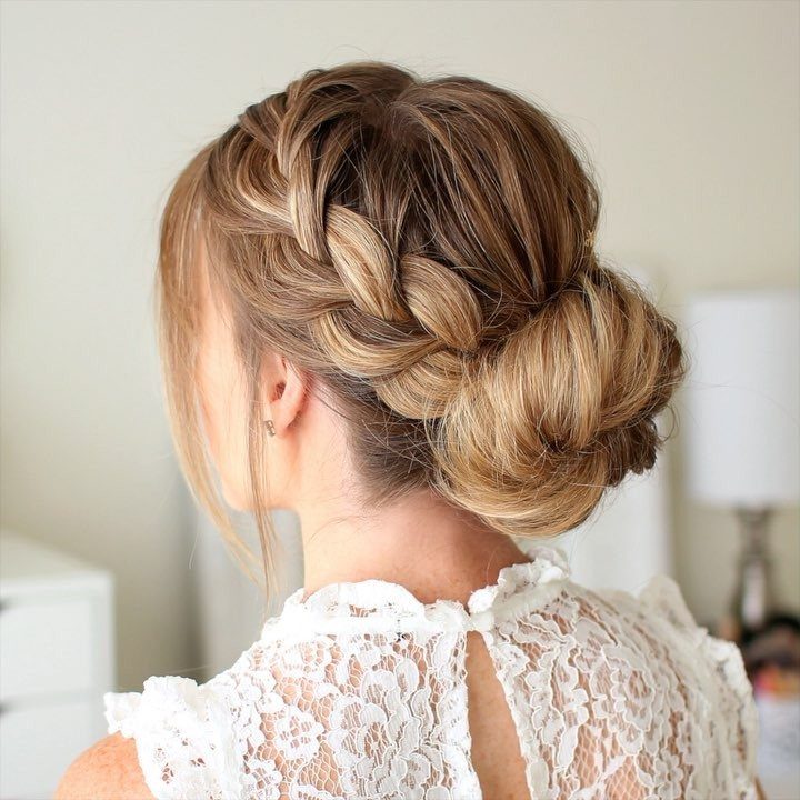 Blonde hair styled in a thick braid leading into a low bun.
