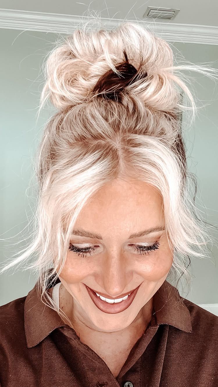 Woman with blonde hair styled in a casual, voluminous messy bun.
