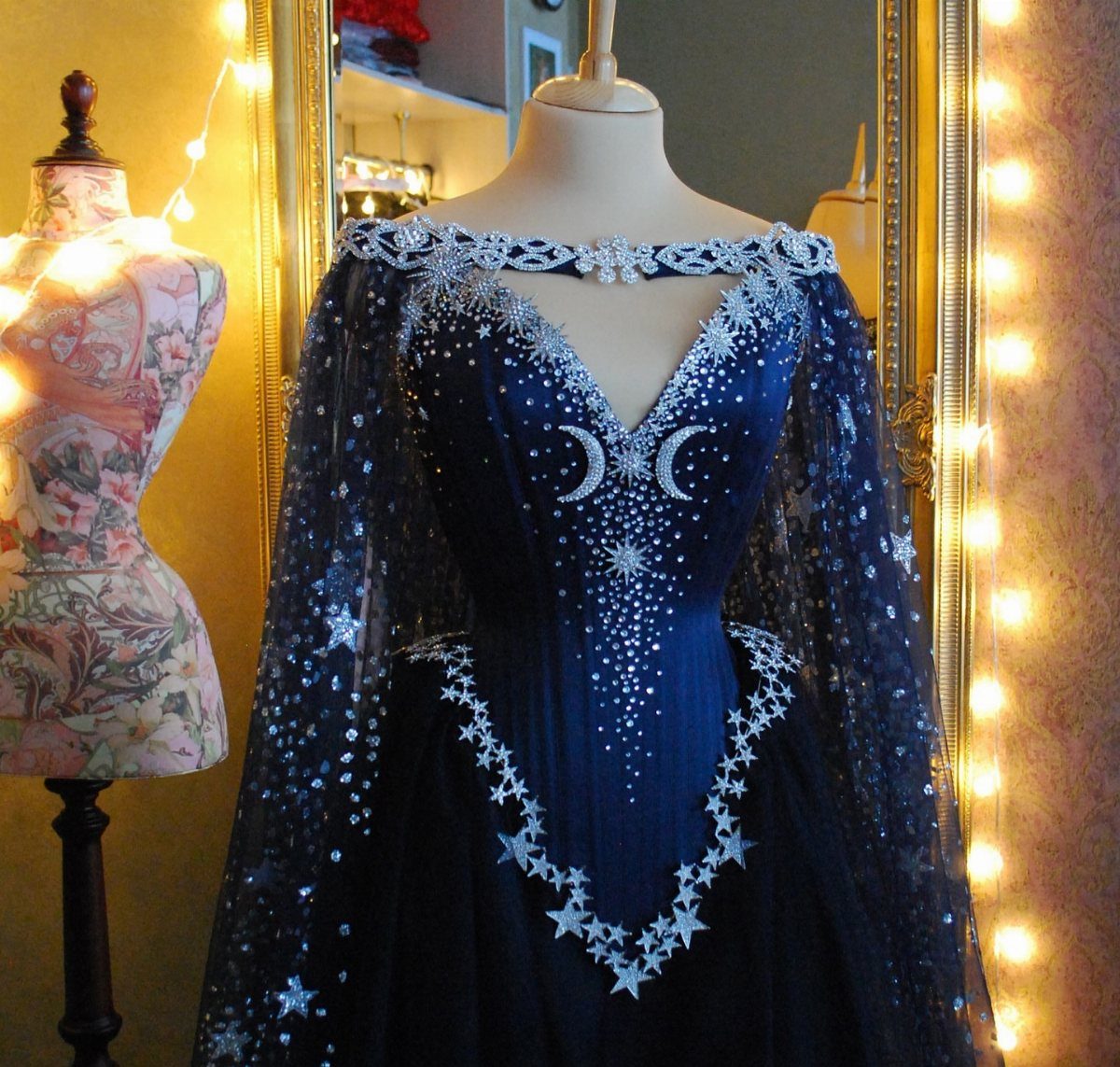 Dark blue celestial gown with silver stars and moons on a mannequin