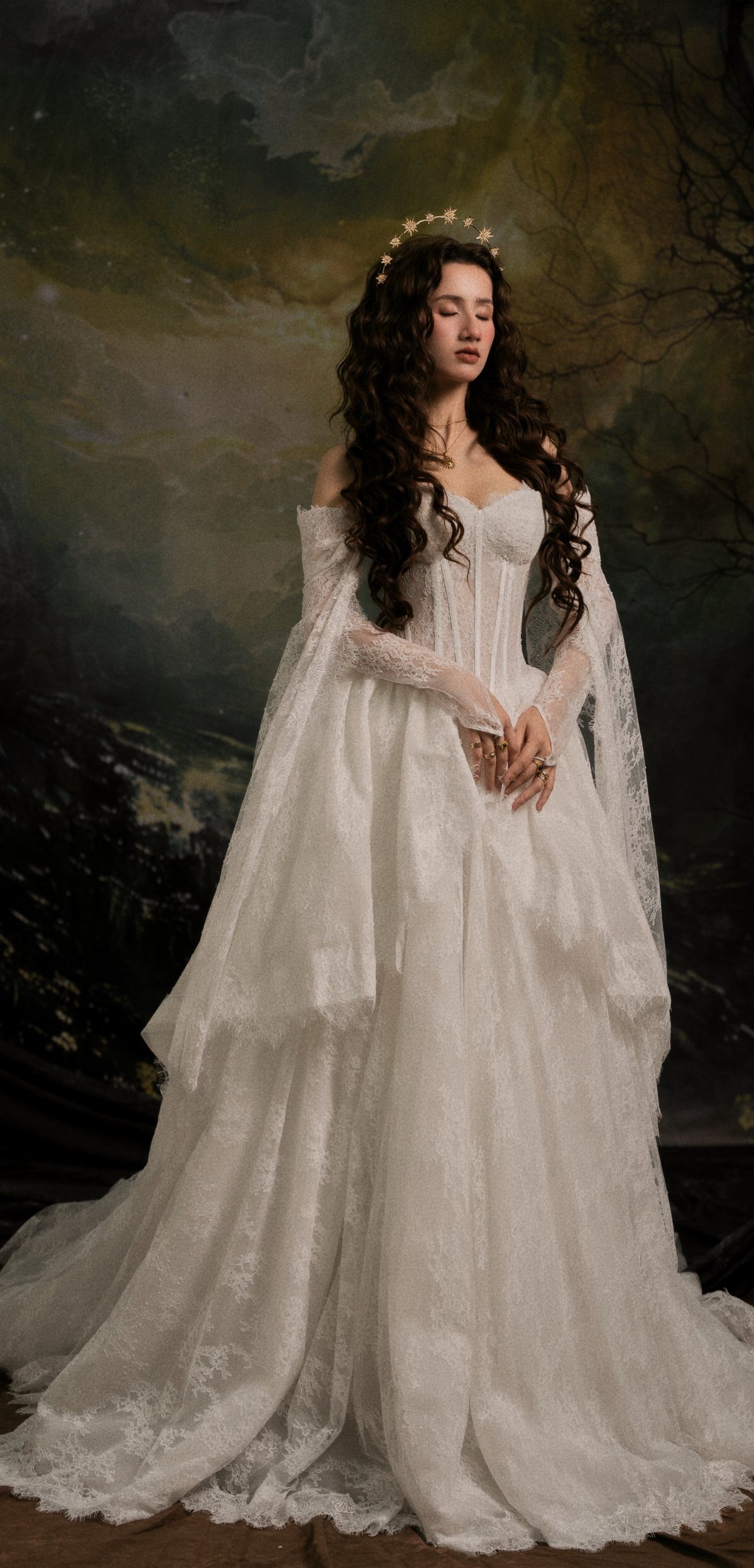 Woman in a white lace and tulle wedding gown with a gold crown.