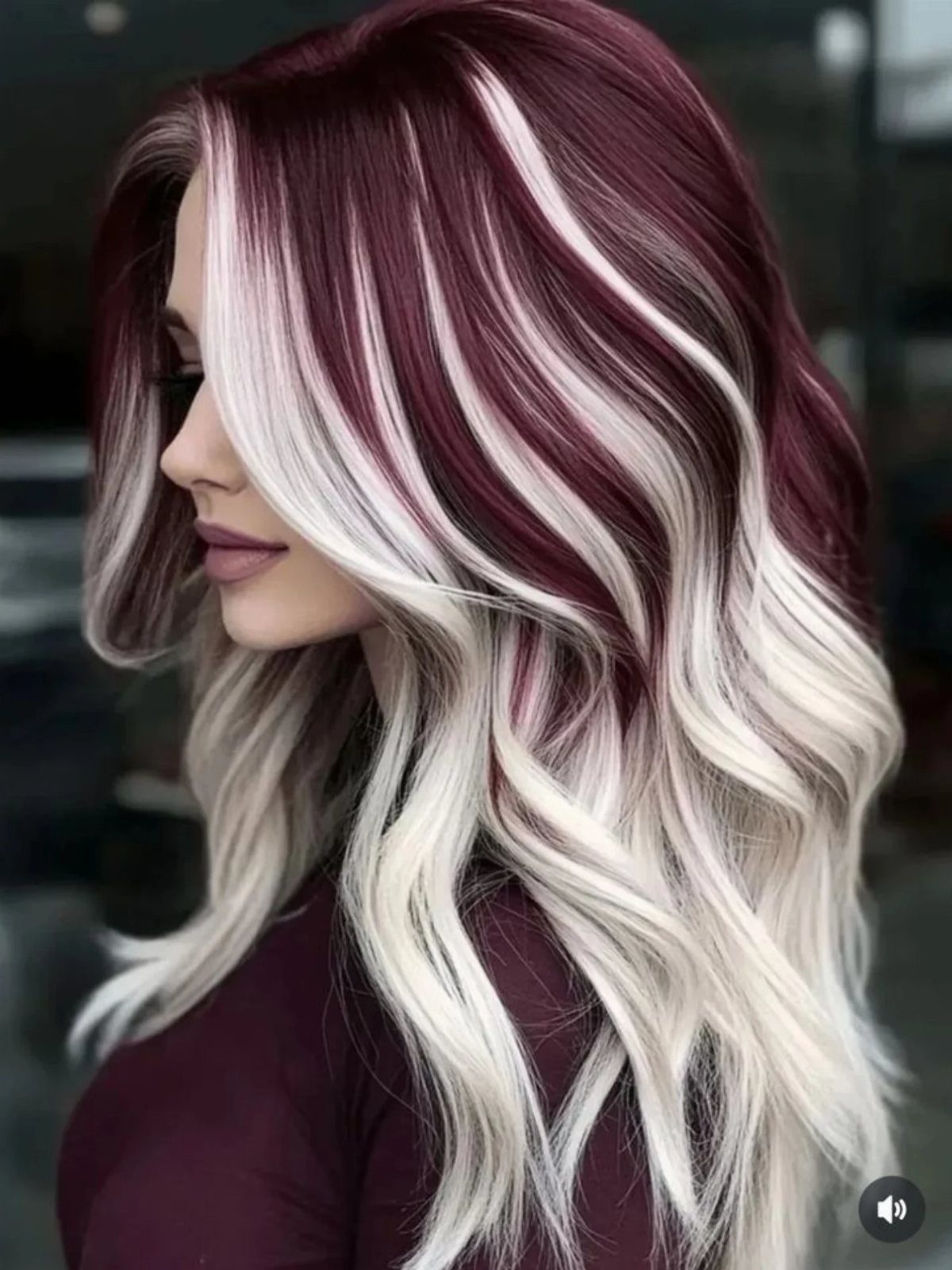 Woman with long wavy hair in deep maroon and platinum blonde highlights.