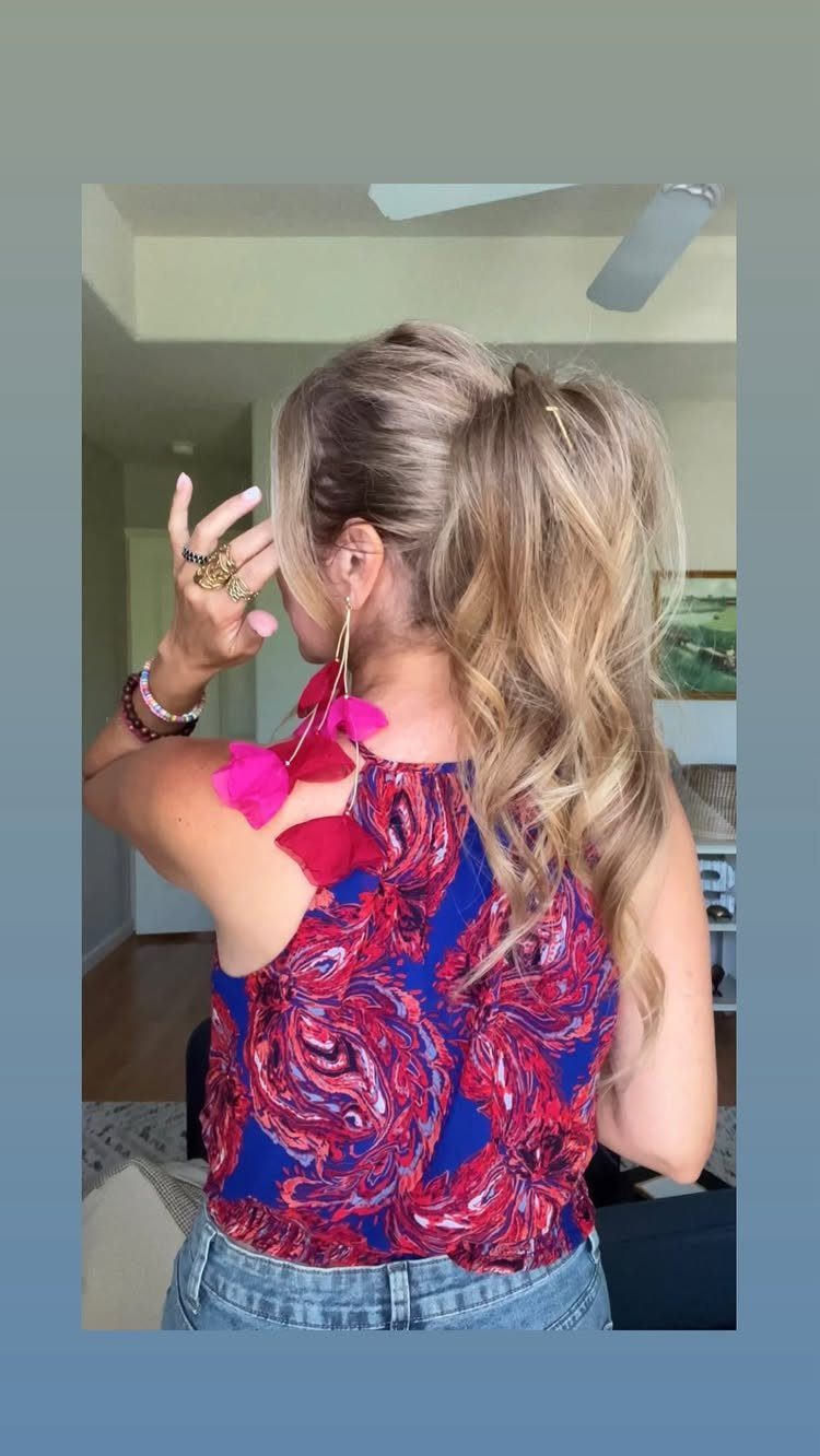 Blonde woman from behind with a high wavy ponytail and pink floral earrings