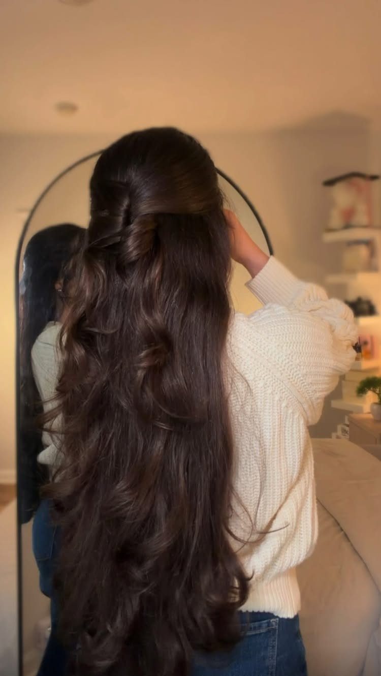 Long wavy brown hair styled in a half-up half-down look from behind.