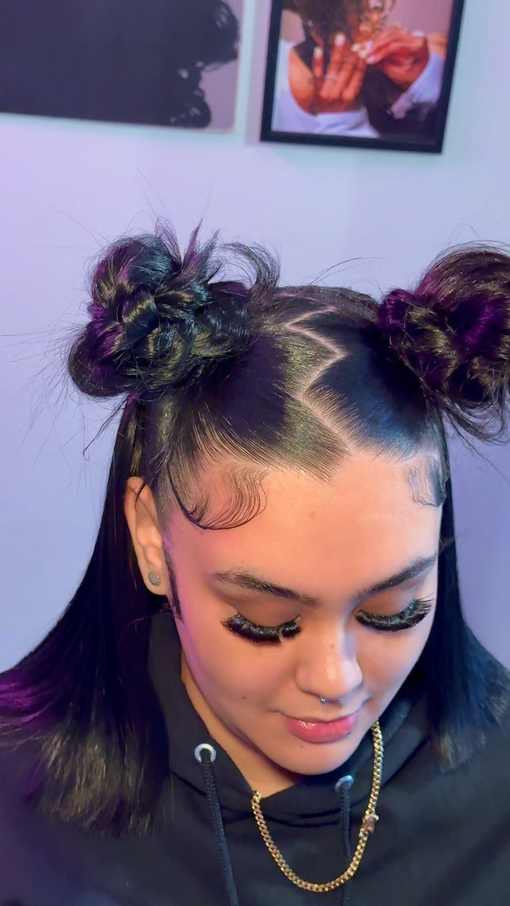 Woman with dark hair styled in two space buns and a black hoodie.
