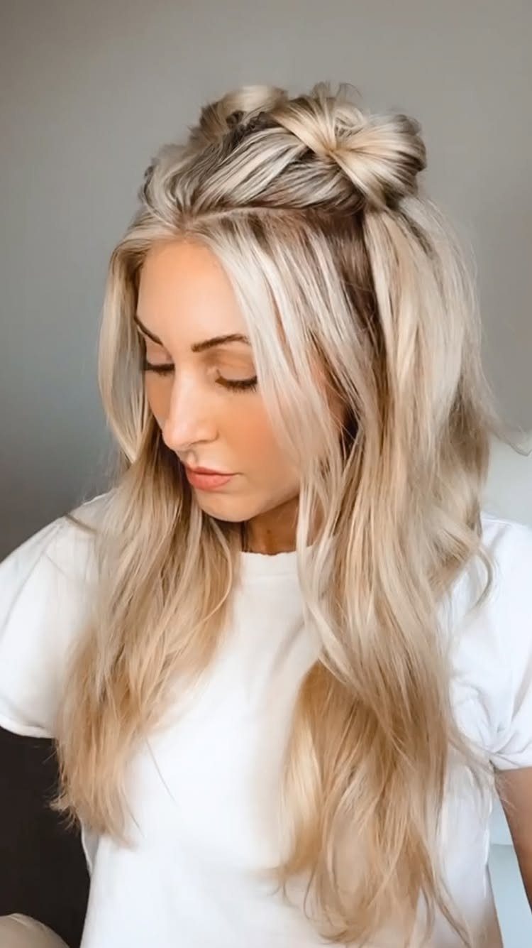 Woman with blonde hair styled in a half-up twisted bun and loose waves.
