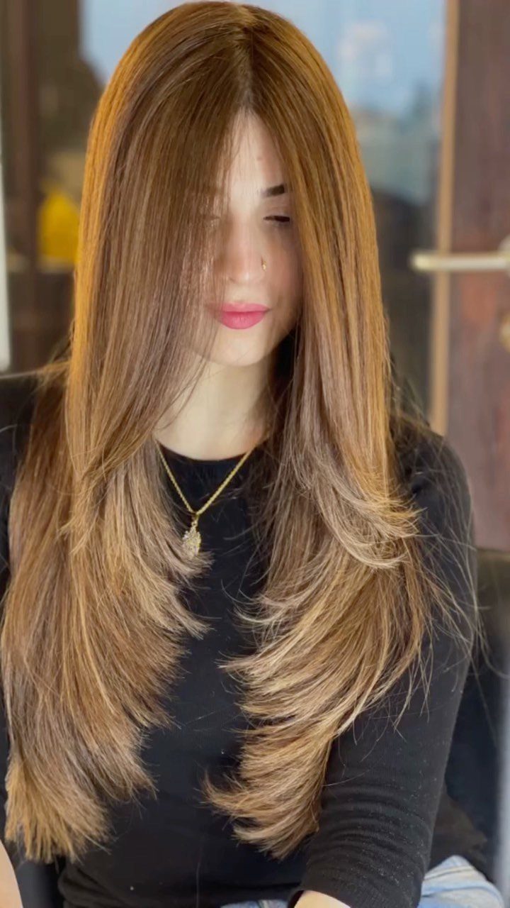 8 Honey Blond with Highlights Ideas for Every Look 1 Woman with long layered brown hair and honey blonde highlights wearing black top