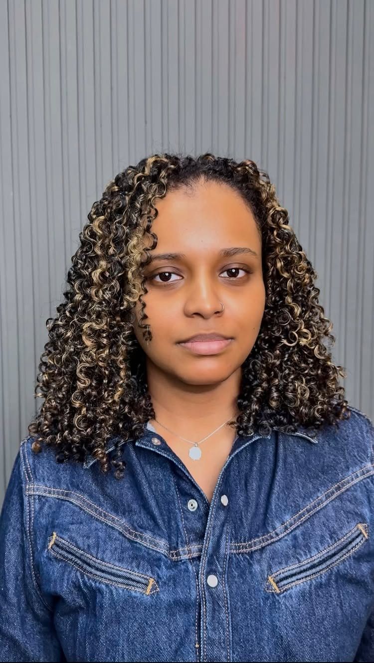 8 Honey Blond with Highlights Ideas for Every Look 3 Woman with curly honey caramel blonde highlighted hair wearing a blue denim shirt