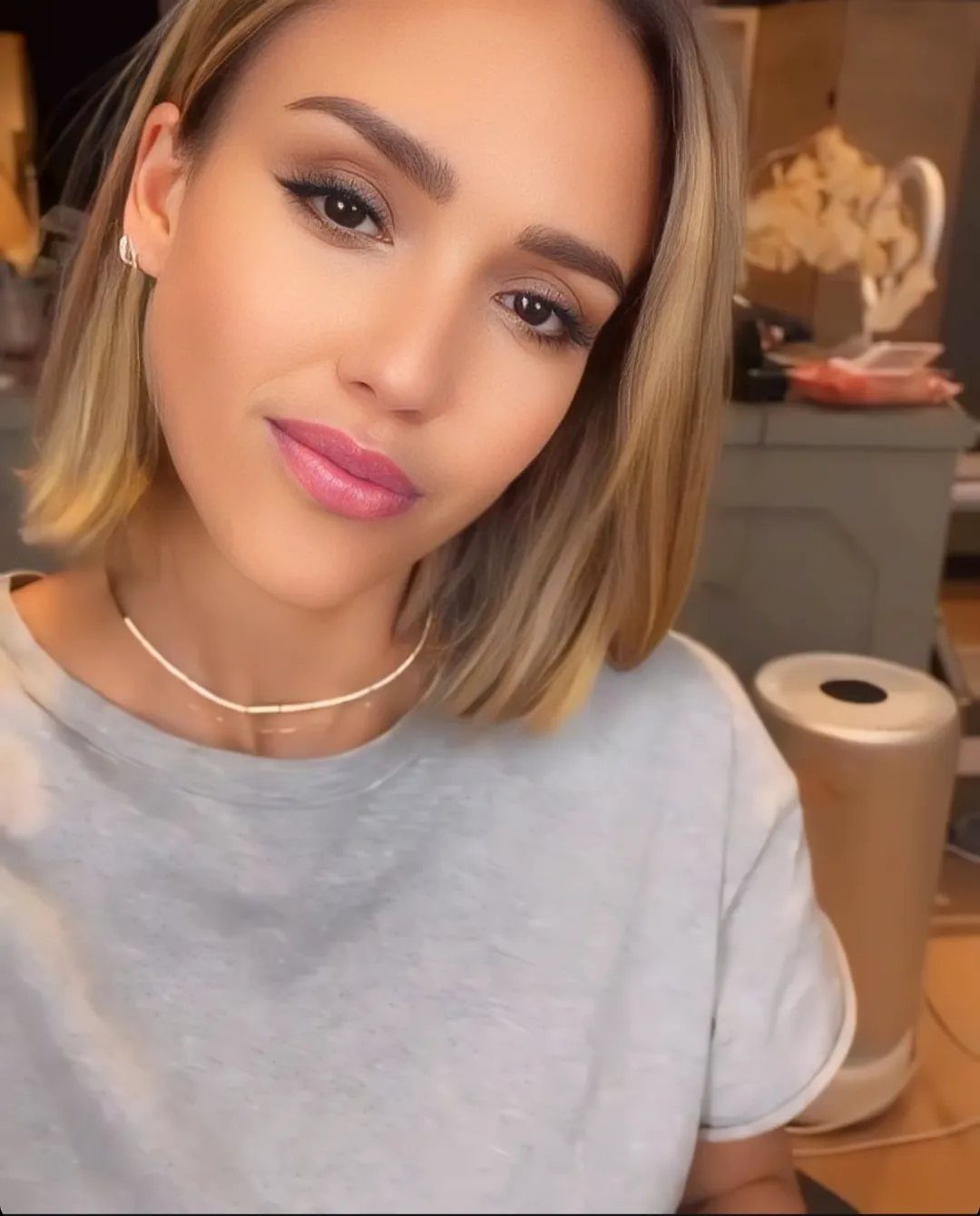 Woman with a straight honey-blonde chin-length bob wearing a grey t-shirt.