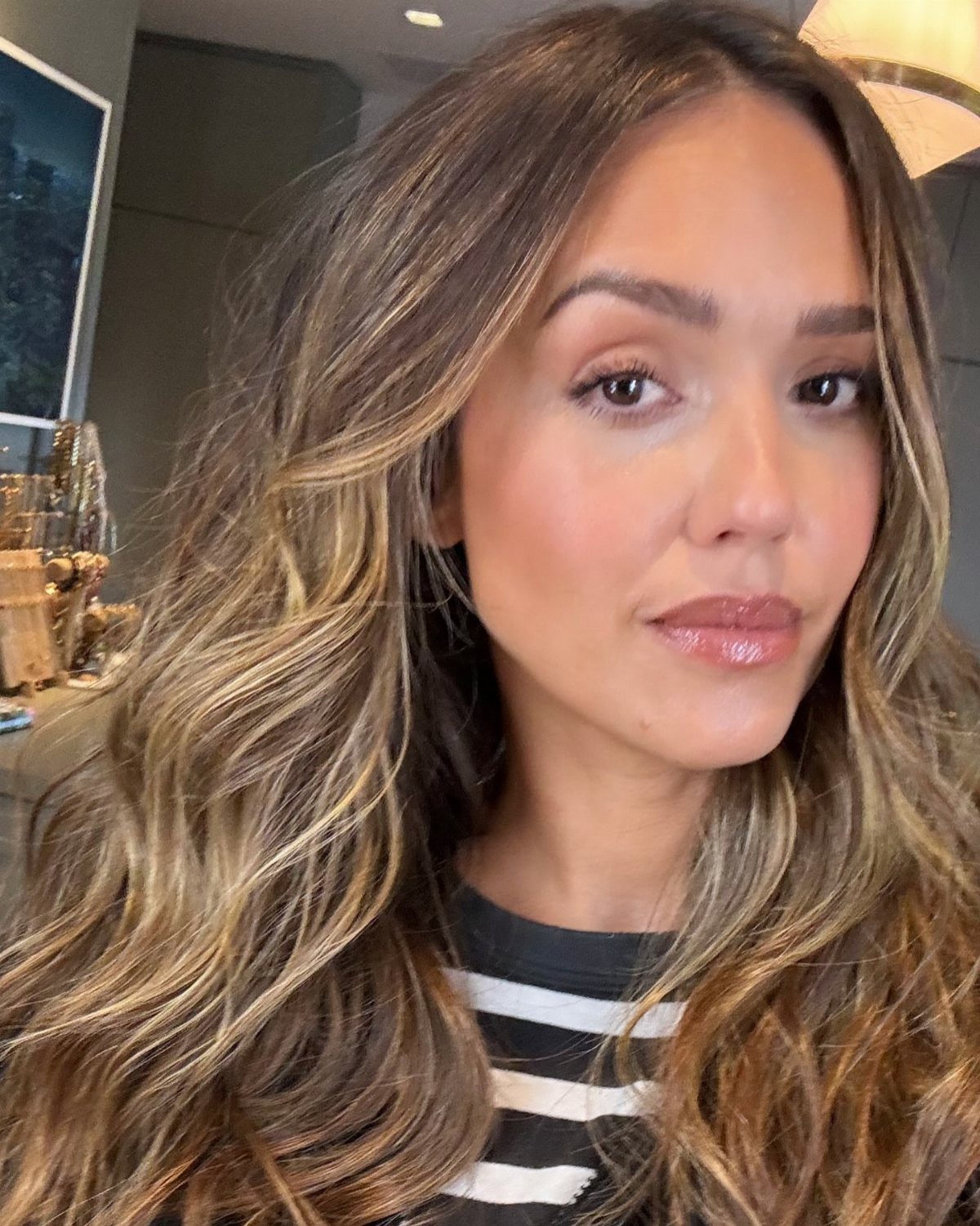 Jessica Alba with long honey-blonde hair styled in voluminous waves and face-framing layers.