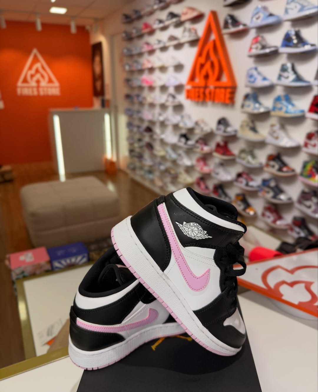 Black and white Air Jordan 1 sneakers with pink accents in a shoe store