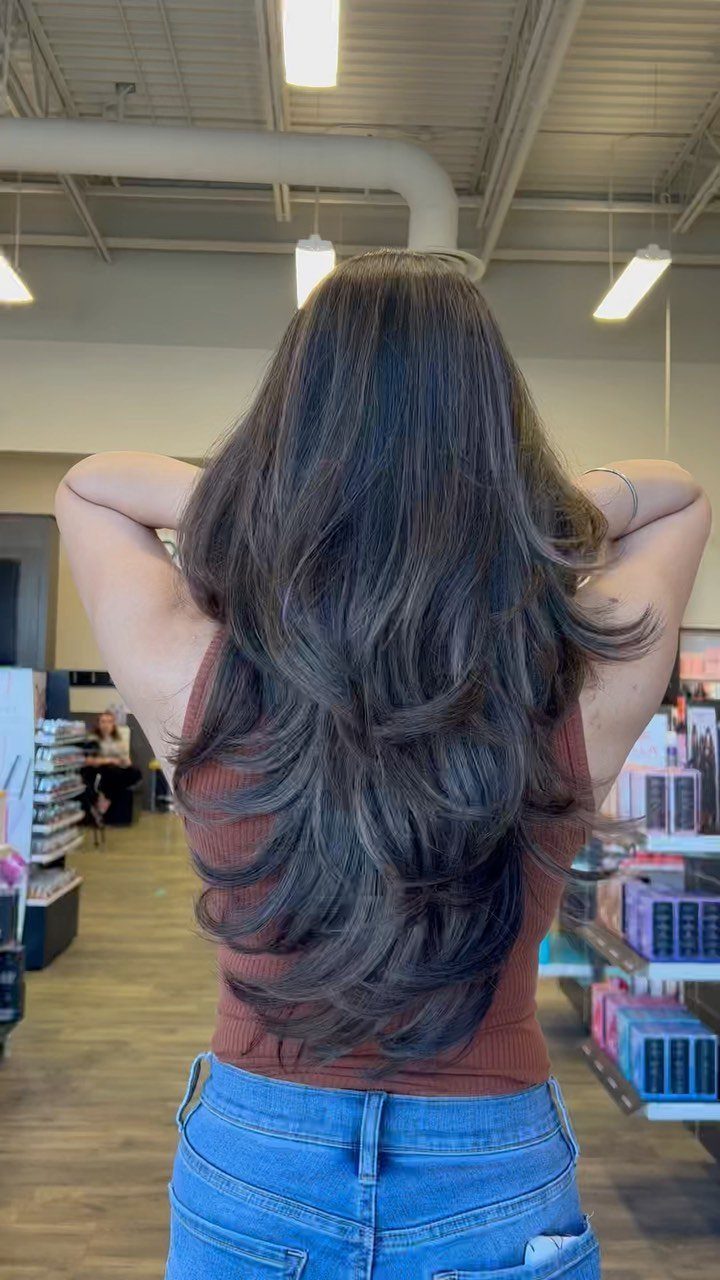 Long dark brown hair with voluminous layers and a rounded U-shaped hemline.