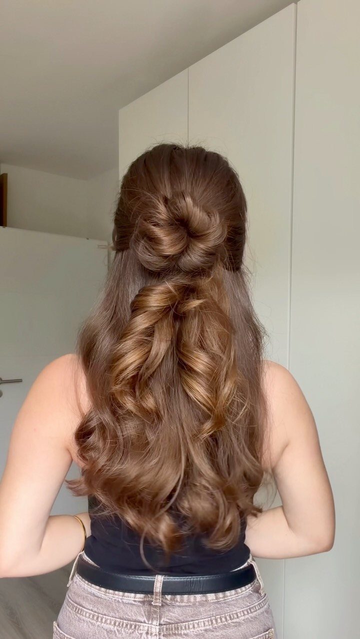 Long wavy brown hair styled in a half-up half-down bun from behind.