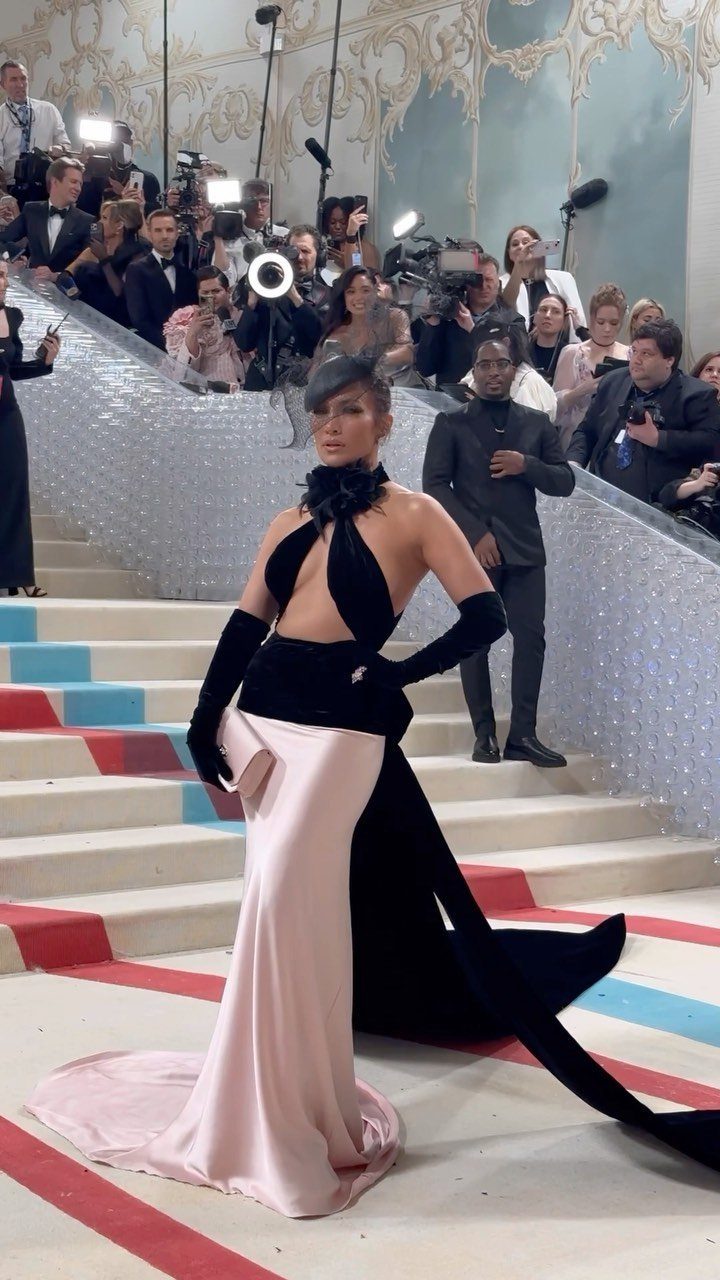 Woman in a black and pink avant-garde gown posing on a grand staircase